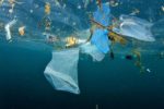 Plastic ocean pollution – plastic bag and rubbish floating in ocean.